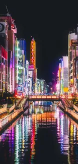 Vibrant cityscape at night with colorful reflections on the river.