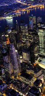 Aerial night view of city skyline with illuminated buildings and streets.