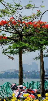 Cyclist rides under flowering trees in vibrant cityscape.