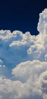 Fluffy clouds against a deep blue sky wallpaper.