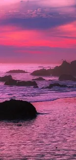 Vibrant coastal sunset with pink and purple hues over a rocky shoreline.