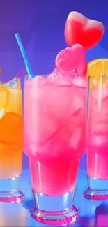 Vibrant neon drinks with pink and orange hues and fruit slices in glass.