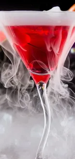 Red cocktail with swirling smoke in glass.