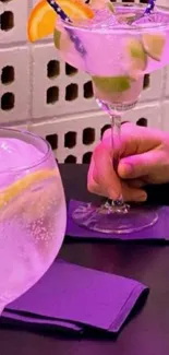 Vibrant cocktail glasses with fruit garnishes on a stylish table.