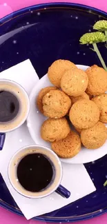 Coffee and cookies on a blue plate with pink background.