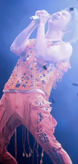 Dynamic performer on stage in vibrant peach outfit with exciting energy.