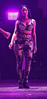 Girl on stage with purple lights and ornate leggings in a concert setting.