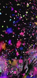 Vibrant confetti shower on a black background with hands reaching up.