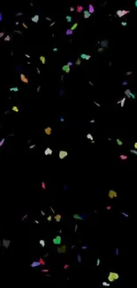 Colorful heart-shaped confetti on a black background.