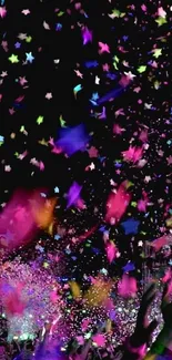 Colorful confetti showering over hands at a festive event.