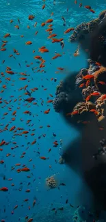 Colorful coral reef with swarming fish in blue ocean water.