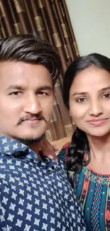 A vibrant selfie of a smiling couple with colorful outfits.