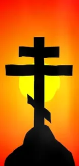 Silhouette of a cross against a vibrant orange sunset background.