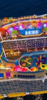 Aerial view of a colorful cruise ship deck, vibrant and illuminated at night.