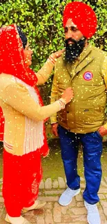 Couple in traditional attire with vibrant red and green background.