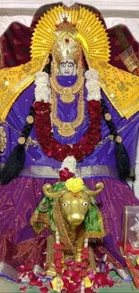 Vibrant deity with purple and gold attire, adorned with flowers.