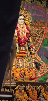 Colorful deity with intricate decorations and floral garlands.