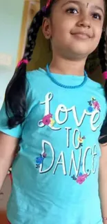 Child wearing blue 'Love to Dance' shirt, smiling brightly.