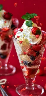Delicious berry parfaits with cream in glass cups on a red background.