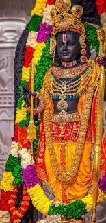 Vibrant deity statue adorned with colorful garlands and ornate decor.