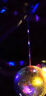 A colorful disco ball reflecting lights in the dark.