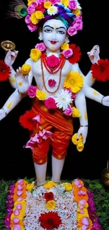 Vibrant Hindu deity with colorful flowers and divine symbols on a black background.