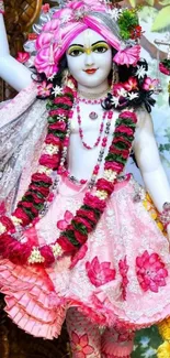 Hindu deity in pink floral attire with vibrant colors.