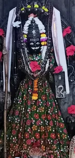 Divine idol adorned with flowers and traditional attire in a serene setting.