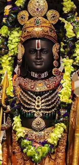 Intricate divine statue with gold accents and colorful garlands.