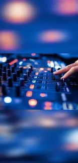 Close-up of hands on a DJ mixer in vibrant blue lighting.