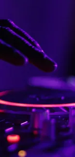 DJ hand on mixer with vibrant purple light.