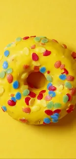 A vibrant yellow donut with sprinkles on a matching background.