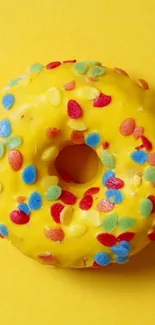 Colorful donut on a vibrant yellow background with sprinkles.