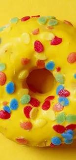 Vibrant yellow donut with colorful sprinkles.