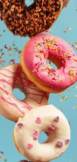 Colorful donuts with sprinkles on sky blue background.