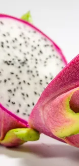 Close-up of pink dragon fruit with white interior on a white background.