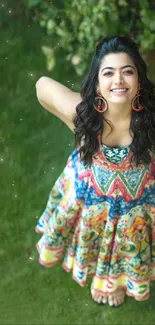 Woman in colorful dress smiling in a lush green garden.