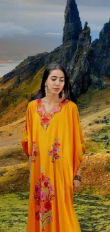 Woman in vibrant dress with mountain landscape backdrop.