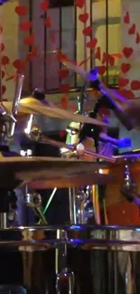 Vibrant drum set in concert setting with colorful lights and energy.