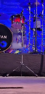 Colorful drum set on a blue stage background with musical instruments.