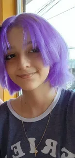 Smiling duo with vibrant purple hair in a colorful cafe setting.