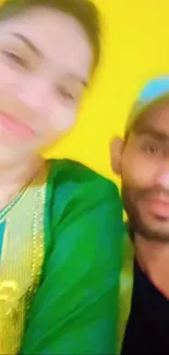 Blurred image of two people against a yellow background.