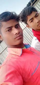 Two young men in colorful shirts pose confidently.