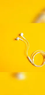 White earphones on a vibrant yellow background.