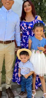 A happy family posing outdoors in colorful clothing.