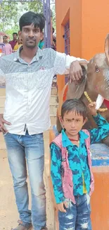 Father and son pose with elephant statue in vibrant setting.