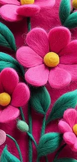 Vibrant felt flowers with green leaves on a pink background.