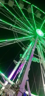 Vibrant Ferris wheel with green lights against a night sky.