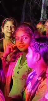 Vibrant crowd at a colorful festival with pink lighting and joyful expressions.