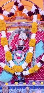 Deity decorated with colorful garlands and vibrant traditional elements.